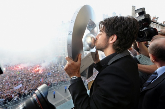 Juninho beija o troféu do Campeonato Francês de 2008 que ganhou com o Lyon em frente à população