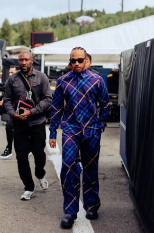 GP da Bélgica - Na Bélgica, Hamilton usou um tracksuit azul e roxo com a clássica estampa da Burberry, junto com botas Chelsea de couro roxas.