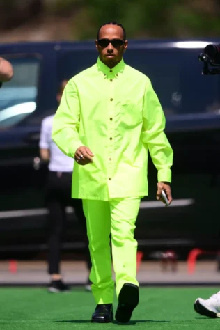 GP da Espanha - Em um look mais estruturado, Lewis Hamilton apareceu usando um conjunto neon da Versace, combinado com botas de bico quadrado, igualmente da Versace.