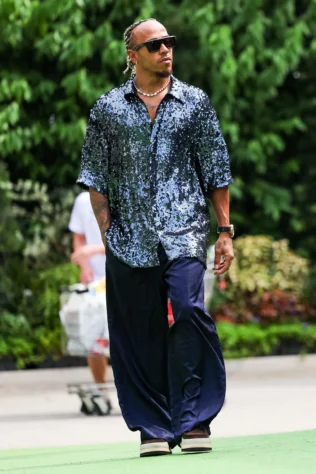 GP de Singapura - Sempre com looks extravagantes, Hamilton ousou em misturar texturas distintas.  O piloto casou uma blusa de botões coberta em paetês azul-marinho, com uma calça fluida e sapatos de plataforma.