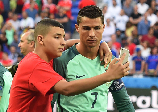 Um dos garotos que entrou em campo com o elenco de Portugal antes da partida, aproveitou pra dar aquela 'tietada' no ídolo português. Nessa foto o CR7 tá sério, mas o garoto tirou boas risadas do 'Robozão' durante o hino. 