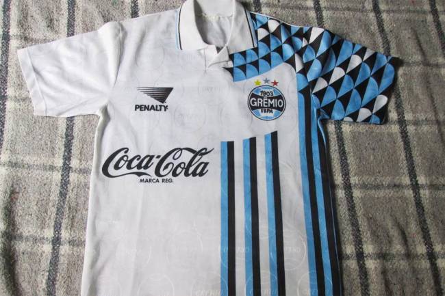 Confesso que essa camisa do Grêmio de 1994 foi uma novidade para o estagiário. A proposta era pra ser essa mesmo, mas parece que faltou tinta pra completar as cores da camisa. O patrocinador ficar de um lado só também é uma novidade (assustadora).