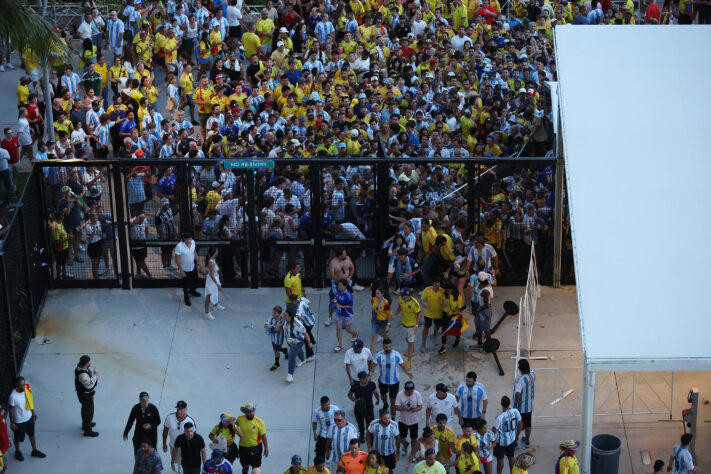 Uma confusão generalizada marcou a final da Copa América. Durante a abertura do Hard Rock Stadium, palco da decisão, muitos torcedores sem ingresso tentaram invadir o estádio e causaram um grande tumulto, deixando pessoas feridas e atrasando o início da partida. Confira as imagens!