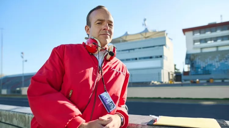 Patrick Kennedy como Ron Dennis, Chefe da equipe McLaren na Fórmula 1, entre 1980 e 2009.