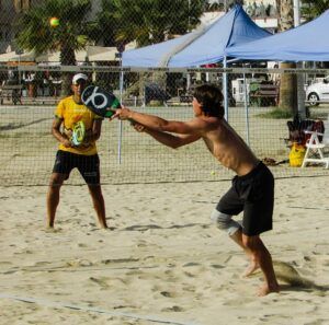 pessoas jogando tênis na praia